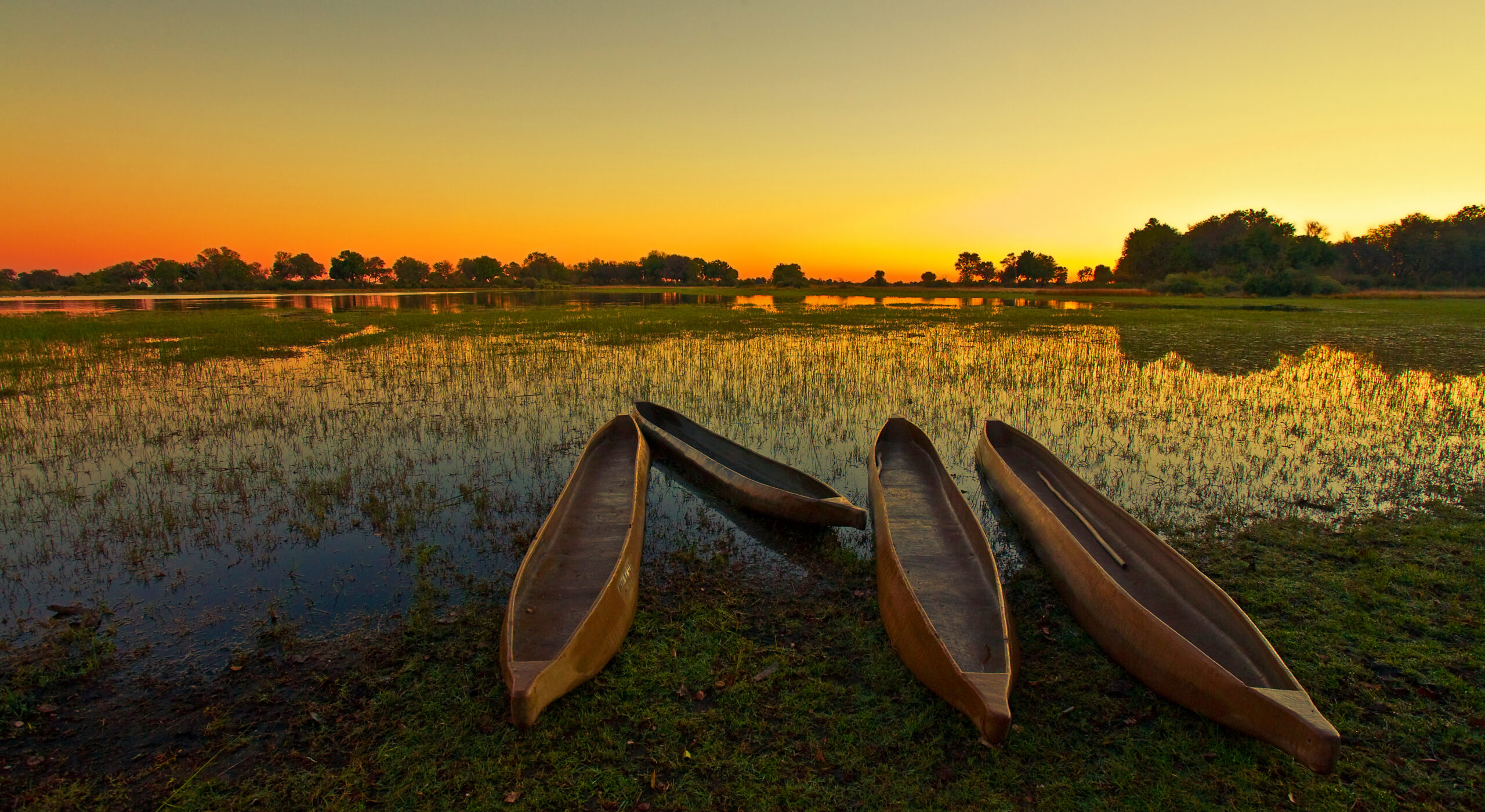Mokoro-Boote im Okavango-Delta bei Sonnenuntergang