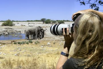 Fotografin mit Teleobjektiv auf Safari in Afrika